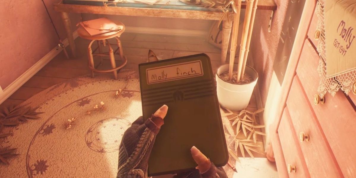 Someone holds a notebook in hand in What Remains of Edith Finch  